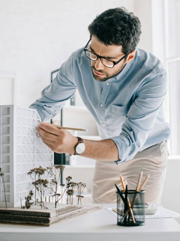 handsome-architect-working-with-architecture-model-on-table-in-office.jpg